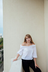 Fototapeta na wymiar Beautiful young woman in white blouse and black pants