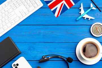 Great Britain flag and toy plane on blue wooden background
