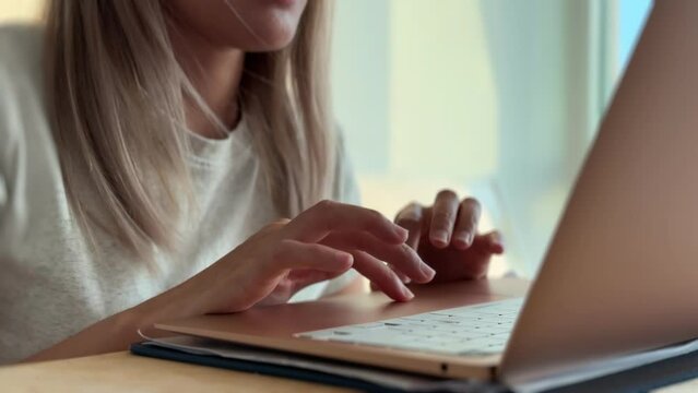 Close up of woman typing and working with computer laptop in her apartment in concept of working from home and overtime freelance.