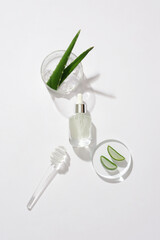 A sleek and minimalistic backdrop featuring transparent glassware and a hydrating serum bottle....