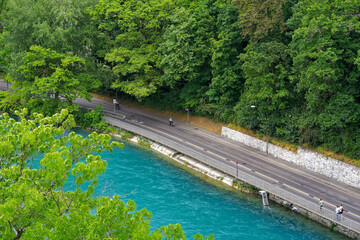 Scenic aerial view of Aare River with trees alongside urban road at Swiss City of Bern a cloudy summer day. Photo taken July 1st, 2023, Bern, Switzerland.