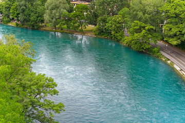 Scenic aerial view of Aare River with trees alongside urban road at Swiss City of Bern a cloudy summer day. Photo taken July 1st, 2023, Bern, Switzerland.
