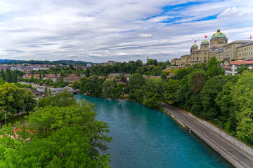 Fototapeta na wymiar Scenic view of Swiss Federal Palace with Aare River in the foreground on a cloudy summer day at Bern, Capital of Switzerland. Photo taken July 1st, 2023, Bern, Switzerland.