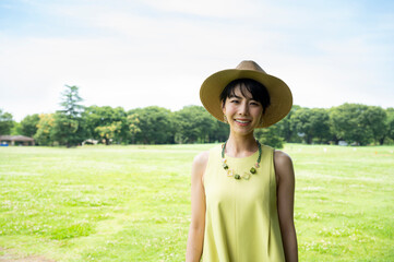 Portrait of a beautiful Asian woman happily smiling in a lush green park.