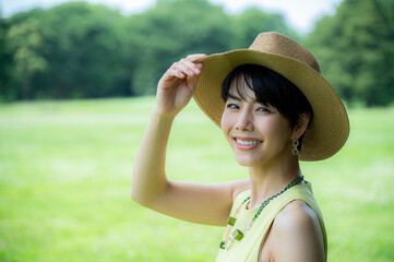 Portrait of a beautiful Asian woman happily smiling in a lush green park.
