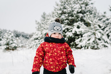 Fototapeta na wymiar Children walking snowy mountains. Serious face. Child playing outdoors. Kid running and enjoying journey in winter forest. Boy plays snow, makes snowballs in park. Frost winter season holidays.