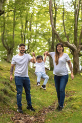 Fototapeta premium Family playing while walking along a forest