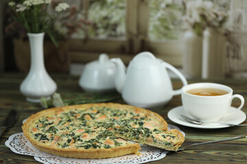 Delicious Quiche pie with salmon fish and pine nuts filling. Breakfast with quiche and cup of tea