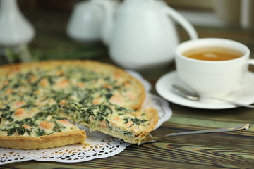 Delicious Quiche pie with salmon fish and pine nuts filling. Breakfast with quiche and cup of tea