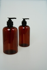 Two dark bottles with soap dispensers on a white background. isolated on white background