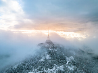 Jested mountain with modern hotel and TV transmitter on the top, Liberec, Czech Republic. Building in clouds. Aerial view from drone.