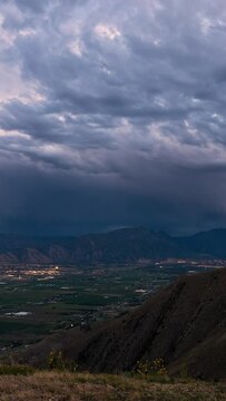 Vertical Timelapse of clouds moving over Utah Valley as city lights turn on from Payson Utah, looking from West Mountain.