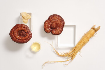 Advertising scene with rare medicine - lingzhi mushrooms and ginseng root displayed on white...