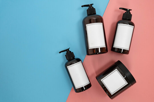 Body care. set of bottles with dispensers and jars of body cream on a blue and pink background. Advertising concept