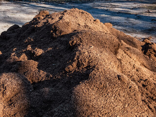 Big pile of dry, brown peat prepared to be used for gardening purposes outdoors
