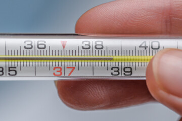 Zbliżenie na termometr rtęciowy pokazujący wysoką temperaturę ciała, gorączka  - obrazy, fototapety, plakaty
