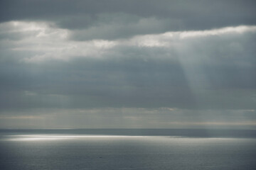 Storm clouds over the sea with sunbeams.