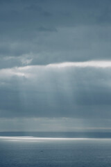 Storm clouds over the sea with sunbeams.