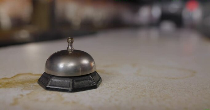 Close-up of a woman's hand ringing a call bell at an old diner