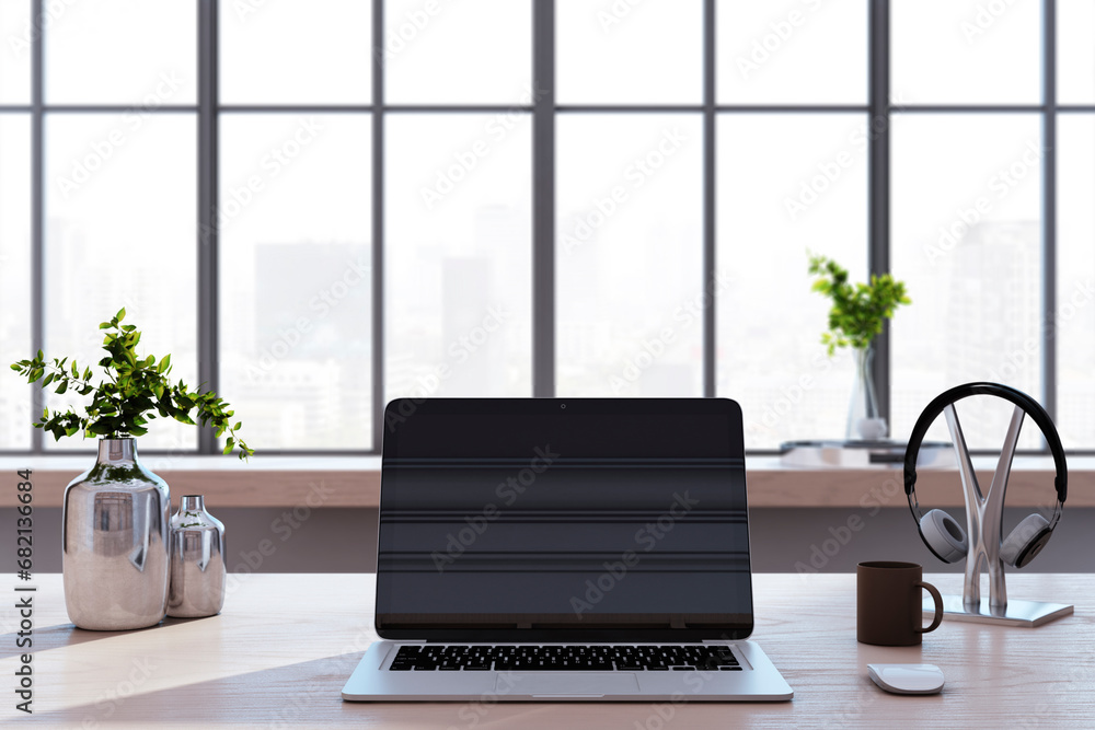Poster close u of creative designer desk with laptop, coffee cup, other items and window with city view in 