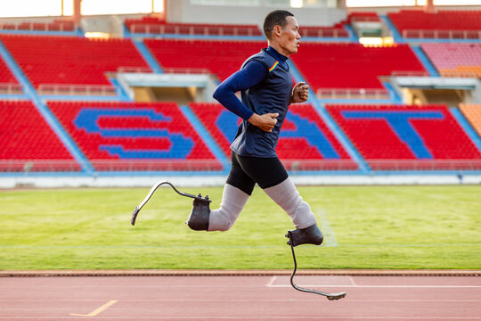 Asian para-athlete with prosthetic blades leg in stadium practicing workout for Paralympic running competition. Amputee sportsman runner practicing running workout. Disabled athlete man sport concept. - Powered by Adobe