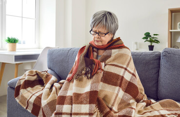 Senior woman feels very cold when she catches the flu or has heating problems in the house. Sick...