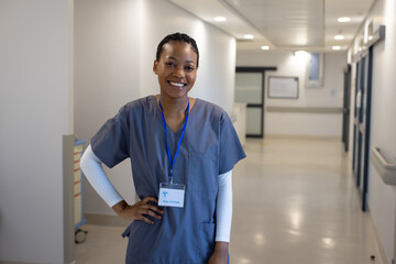 Portrait of happy african american female doctor in hospital corridor