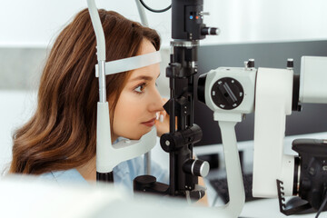 Pretty young woman sitting at an eye tester
