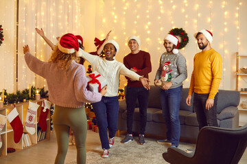 Happy multiracial friends have fun celebrate New Year together at home. Smiling millennial diverse...