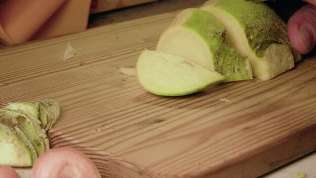 Food prep: Raw turnip vegetable is sliced into pieces, close up view