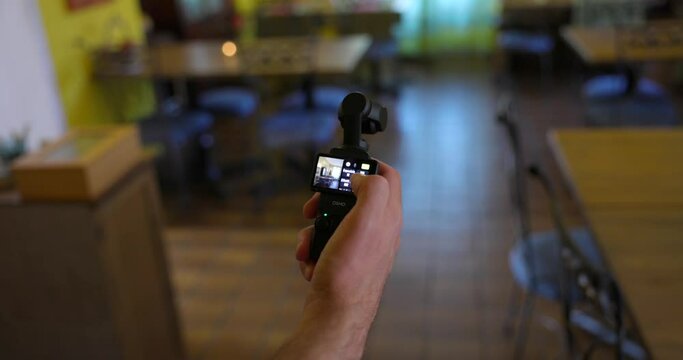 Hand swiping on screen of DJI Osmo Pocket 3 stabilized handheld mobile camera