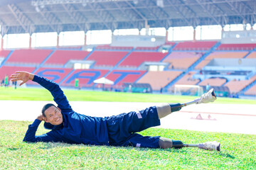 Asian para-athlete with prosthetic blades leg in stadium practicing workout for Paralympic running competition. Amputee sportsman runner practicing running workout. Disabled athlete man sport concept.