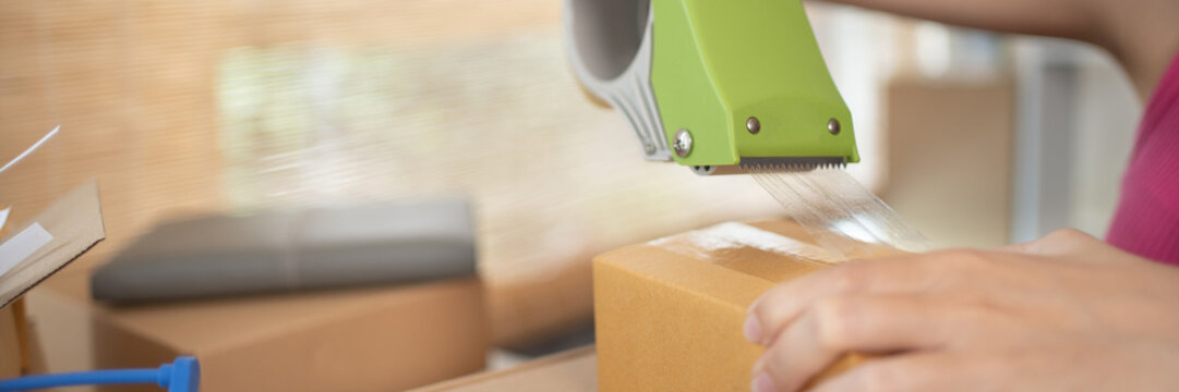 Woman Packing Items Into A Post Box To Prepare For Delivery To A Customer, Working At Home And Owning Businesses, Online Shopping SME Entrepreneur, Packing Box, Sell Online, Freelance Working.