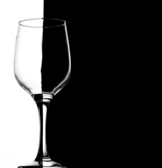 Wine glass on black and white half split background. High contrast.