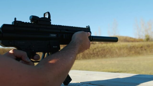 shooting bullet singleshot from Sig MPX K suppressed Karabin GSG 15 BLACK on sunny blue sky shooting range