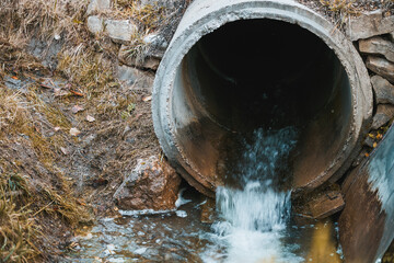 Wastewater sewage flows from a pipe into the river. Tackling Pollution. Managing Wastewater and...