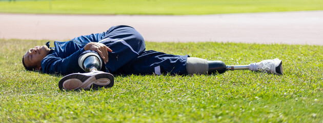 Asian para-athlete with prosthetic blades leg in stadium practicing workout for Paralympic running competition. Amputee sportsman runner practicing running workout. Disabled athlete man sport concept.