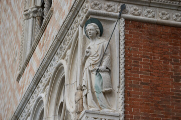 Obraz premium Statue of archangel Raphael wit a spear on the exterior of the Doge's Palace (Italian: Palazzo Ducale), one of the main Venetian landmarks. Venice - 5 May, 2019