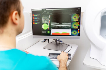 Male ophthalmologist working on a computer in a clinic
