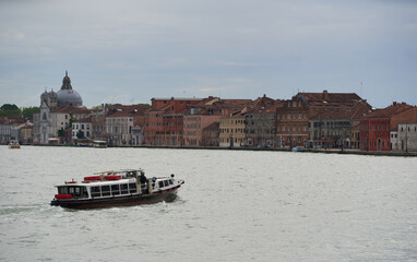 Venetian water bus crusing in canal between Dorsoduro and Guidecca. Venice - 6 May, 2019