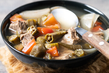 Traditional African okra soup on wooden table. Close up