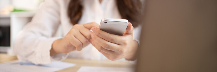 Young women use smartphones to play games or watch video clips to relax after a break from...