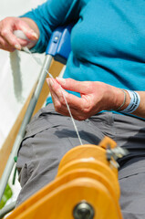 A woman spins wool using a traditional spinning wheel.