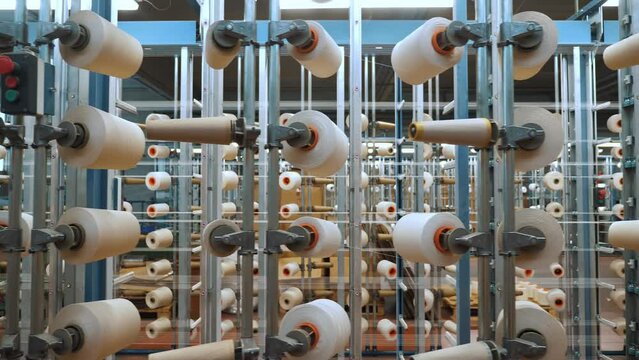 thread spools. textile industry. weaving factory. racks with many thread spools. dyeing and drying of threads for further fabric production. automated work process. textile manufacture. 