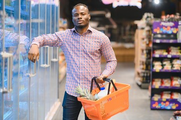 Young african man buying in grocery section at supermarket