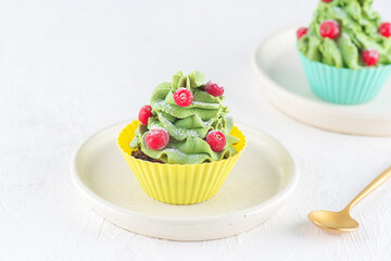 Vegan cupcakes in the form of a Christmas tree with coconut cream and cranberries. Gluten, lactose, sugar free.