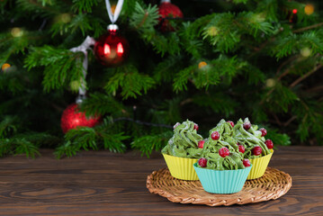 Vegan green cupcakes on the background of the Christmas tree. Gluten, lactose, sugar free.