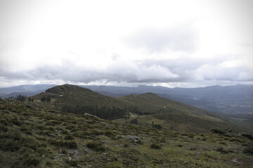 Hills with clouds in Galicia - A stark portrayal of a deforested area in the mountains of Galicia, revealing the environmental impact on the landscape.