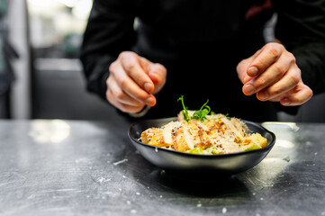 Chef cooking Caesar salad on restaurant kitchen