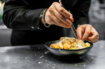 Chef cooking Caesar salad on restaurant kitchen